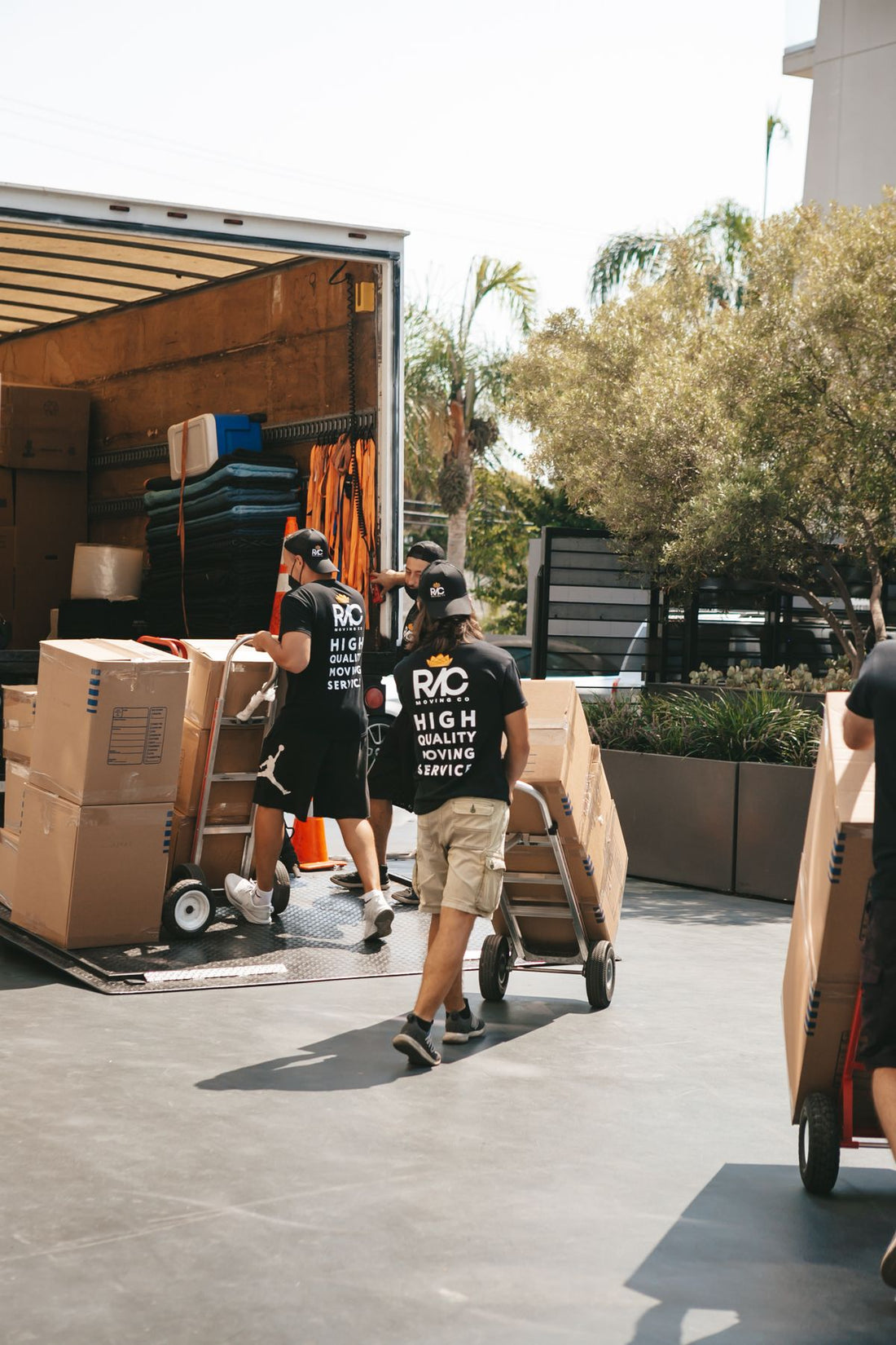 Movers loading boxes into a truck on a trolley