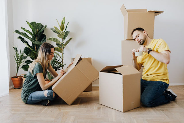 Couple packing belongings into boxes at home
