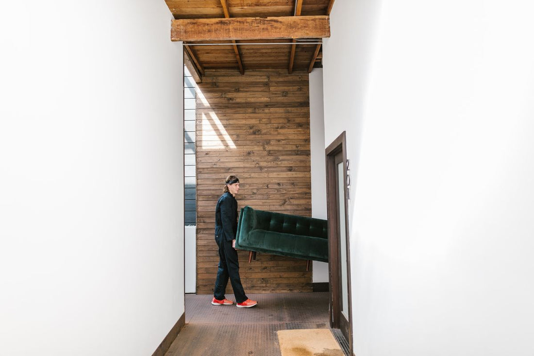 Mover carefully carrying a large item through a hallway