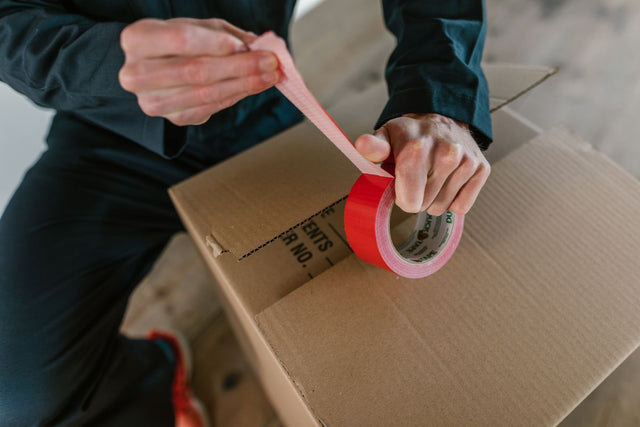 Sealing a cardboard box with packing tape